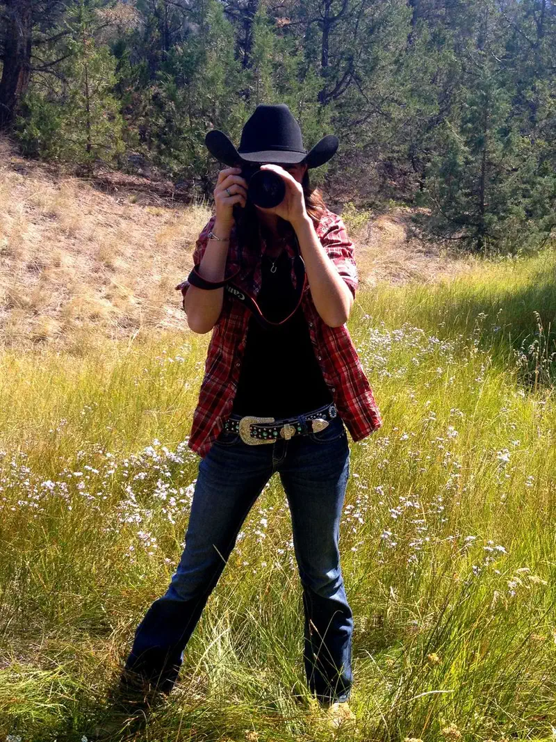Jessie Cloutier photographing outdoors in a cowboy hat